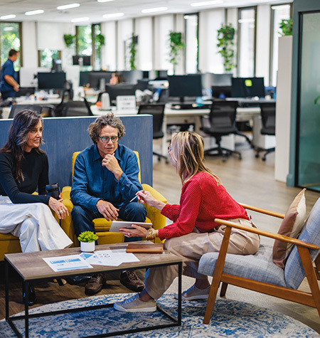 Mature coworkers sharing a lively and engaging conversation in a modern office sitting area